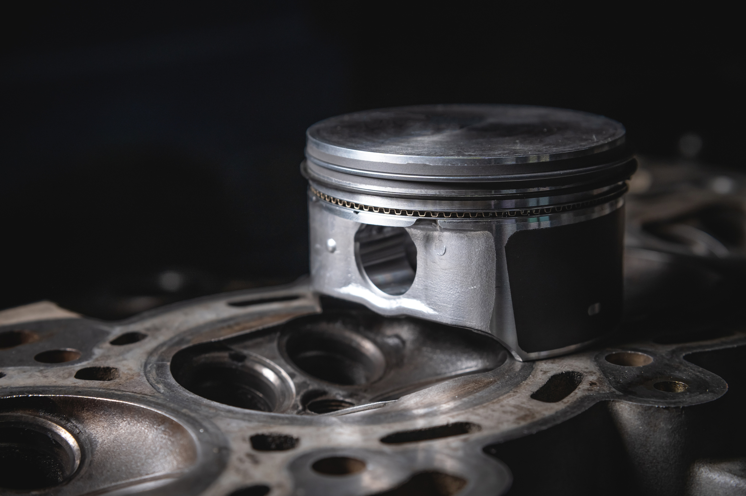 a new repair piston of the internal combustion engine lies on a disassembled engine