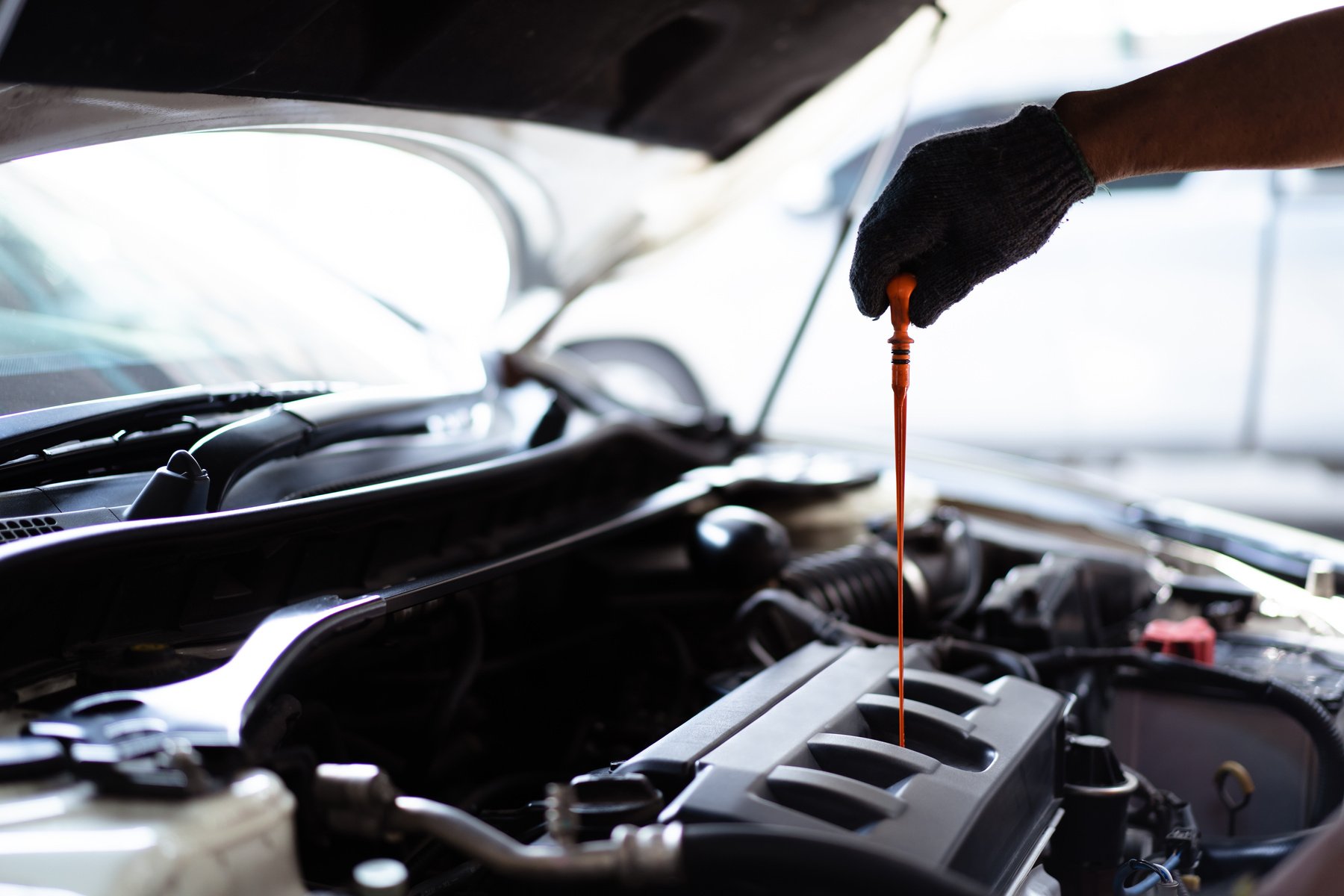 Vehicle technician inspecting an engine oil.